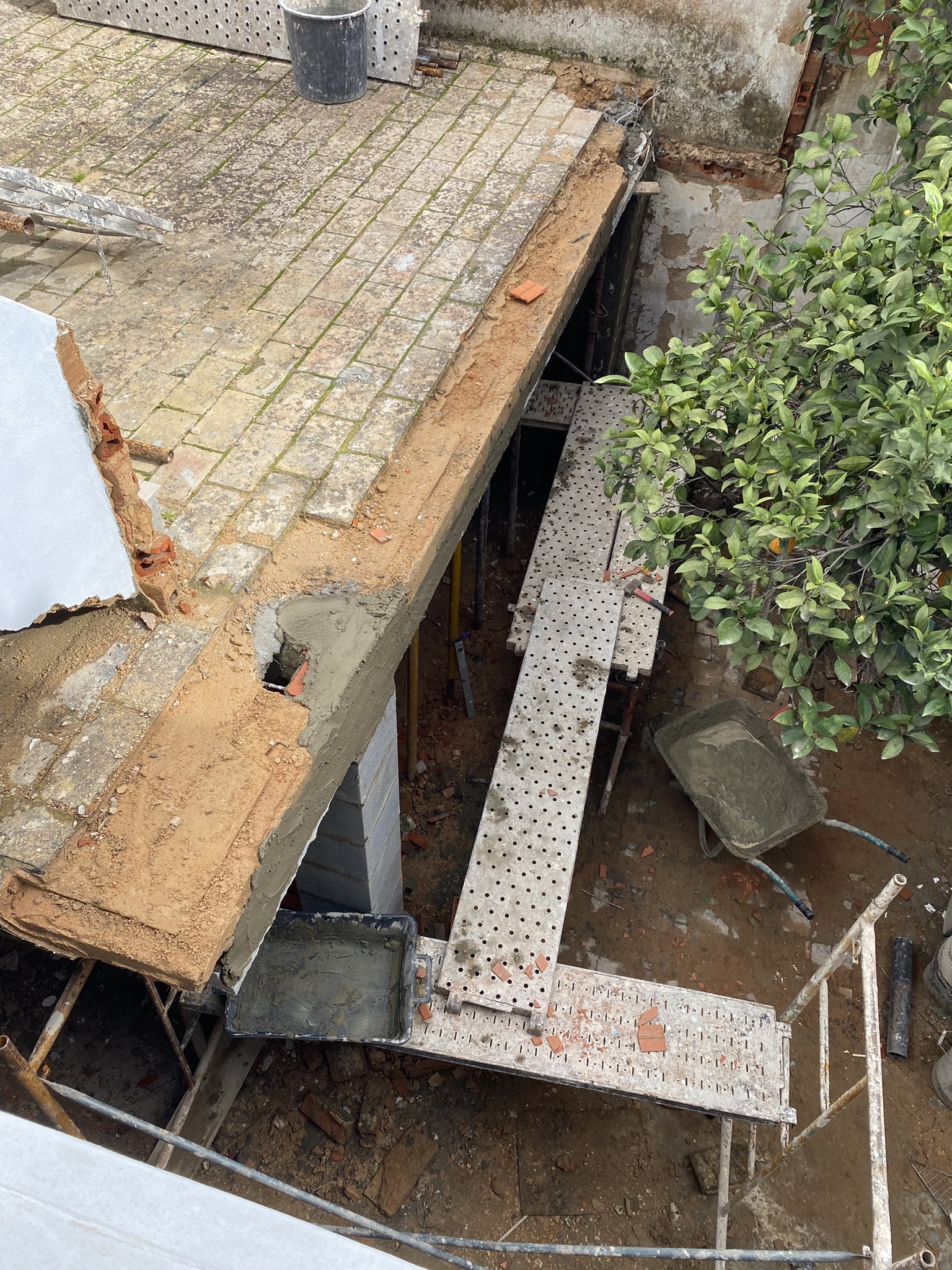 Courtyard image of galeria roof/mezzanine terrasse with pillars, beams and missing stairs